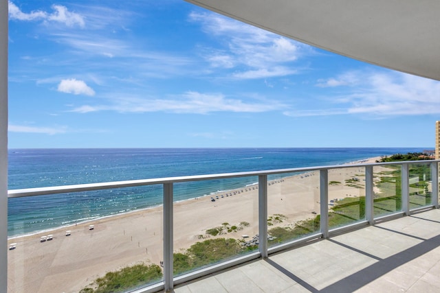 balcony featuring a water view and a beach view