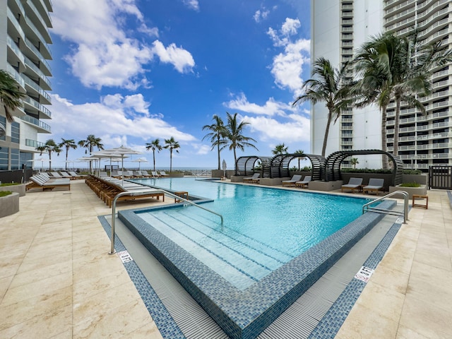 view of swimming pool featuring a patio and a water view