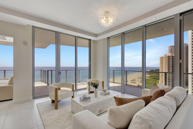 living room with light tile patterned floors, a chandelier, and a water view