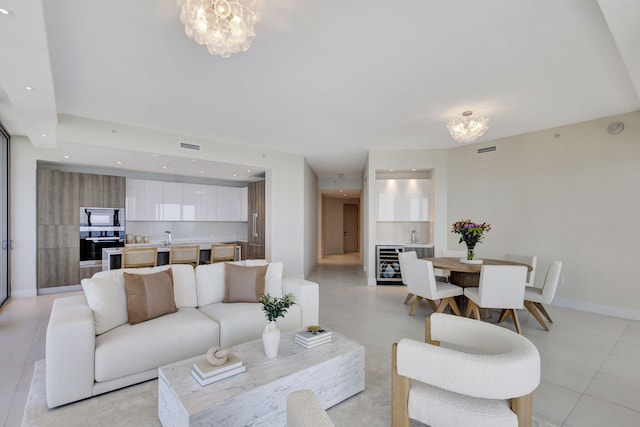 living room featuring beverage cooler and a chandelier