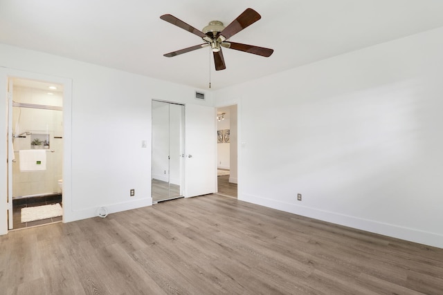 unfurnished bedroom with connected bathroom, light hardwood / wood-style floors, a closet, and ceiling fan