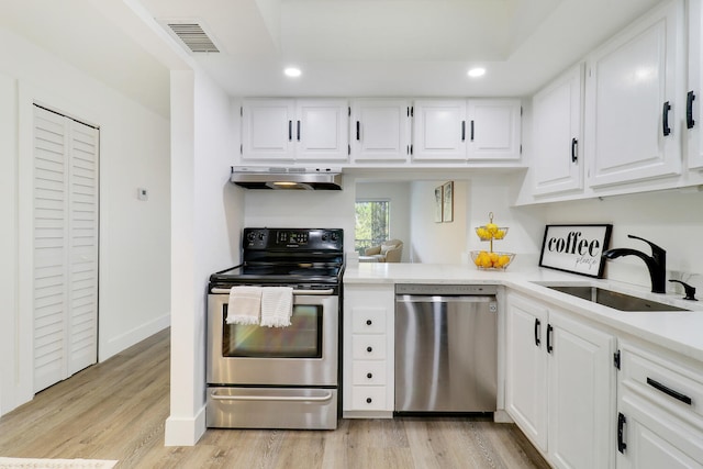 kitchen featuring sink, extractor fan, light hardwood / wood-style flooring, appliances with stainless steel finishes, and white cabinets