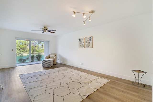 sitting room with light hardwood / wood-style floors and ceiling fan