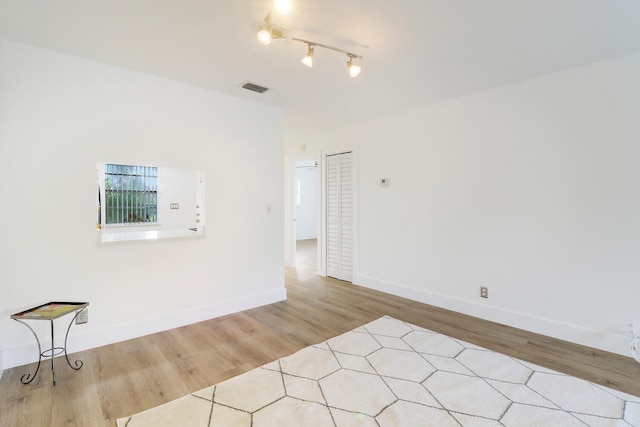 spare room with rail lighting and light hardwood / wood-style flooring