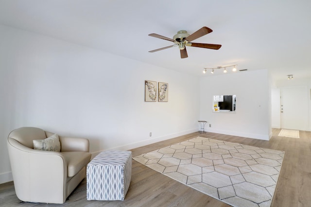 living area featuring light hardwood / wood-style floors and ceiling fan