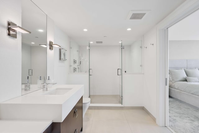 bathroom with tile patterned flooring, vanity, a shower with door, and toilet