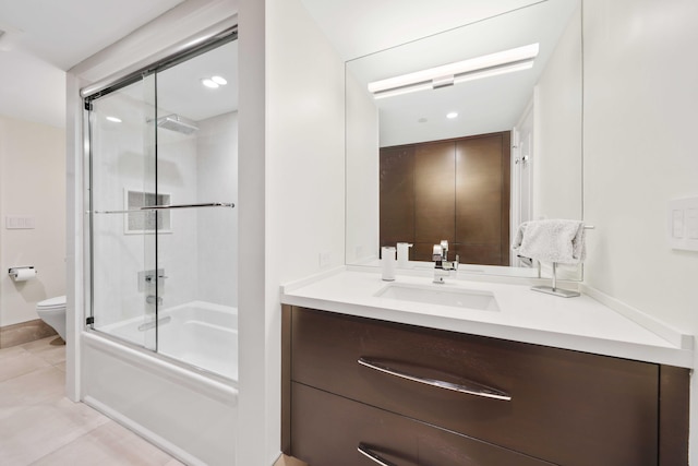 full bathroom with bath / shower combo with glass door, vanity, tile patterned floors, and toilet