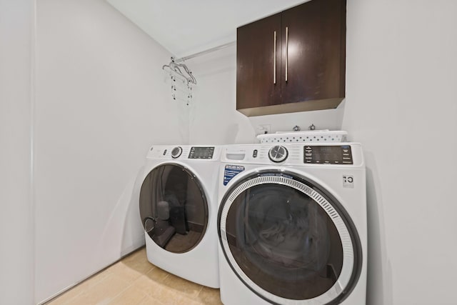 washroom featuring cabinets and washing machine and clothes dryer