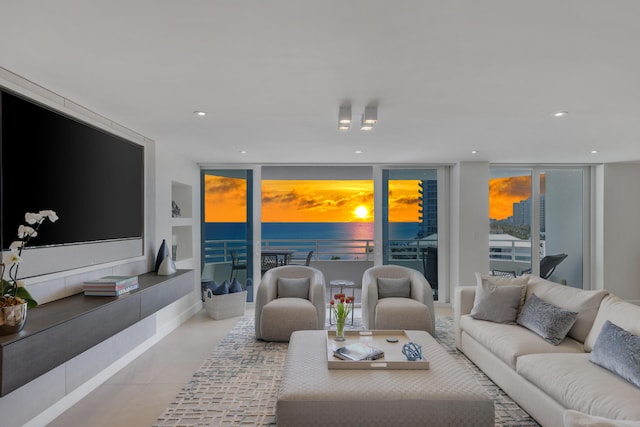 tiled living room with a water view and a wall of windows