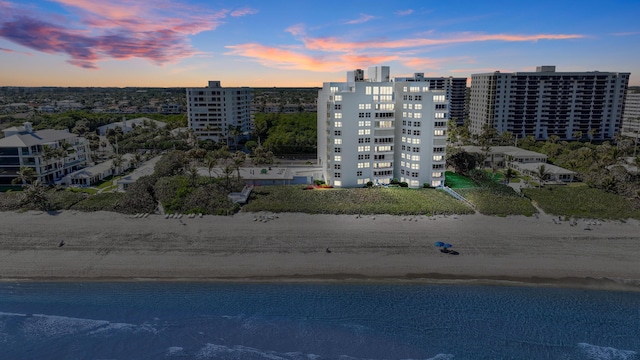 aerial view at dusk with a view of the beach and a water view