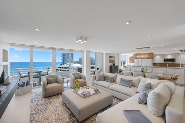 tiled living room featuring floor to ceiling windows and a water view