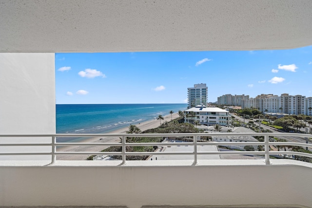 balcony with a water view and a view of the beach