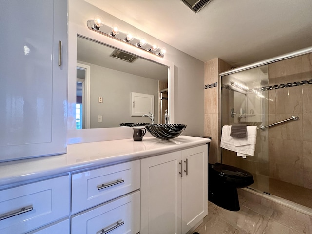 bathroom with vanity, a shower with door, and toilet