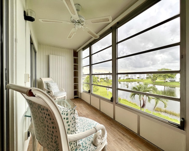 sunroom / solarium with a water view and ceiling fan