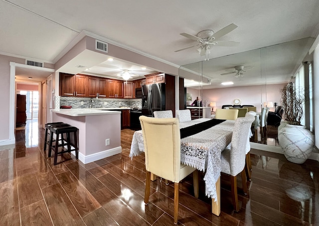 dining area featuring dark hardwood / wood-style flooring, crown molding, and ceiling fan