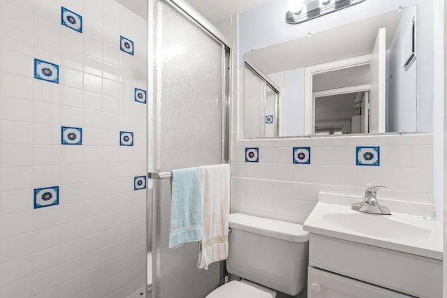 bathroom featuring tile walls, decorative backsplash, vanity, toilet, and a shower with door