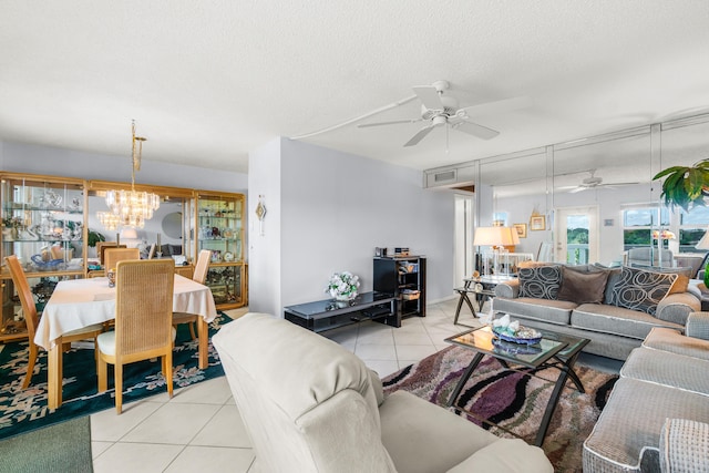 living room featuring light tile patterned flooring, ceiling fan with notable chandelier, and a textured ceiling