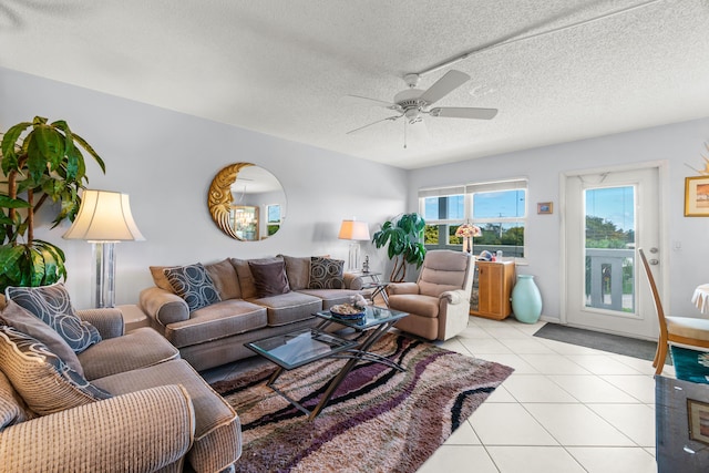 living room featuring light tile patterned floors, a textured ceiling, and ceiling fan