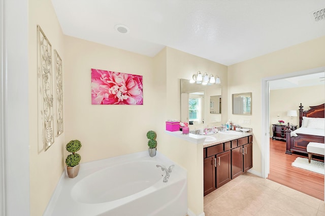 bathroom with vanity, a tub, and tile patterned floors