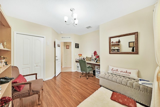 home office with an inviting chandelier and light hardwood / wood-style floors