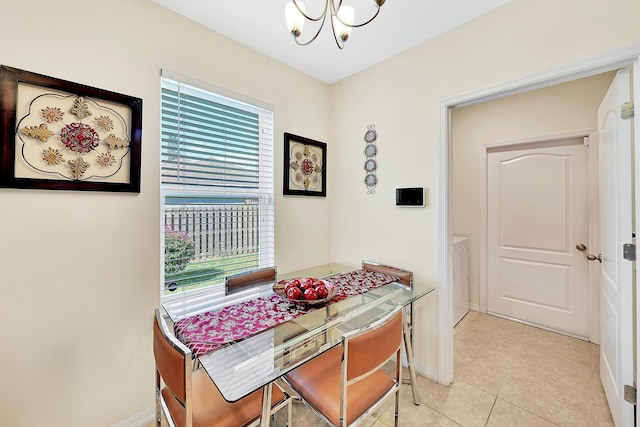 dining area featuring light tile patterned flooring, separate washer and dryer, and a chandelier