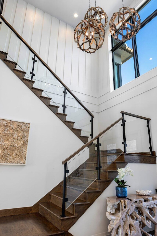 stairs featuring hardwood / wood-style floors and a towering ceiling