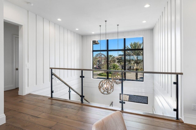 stairway featuring an inviting chandelier and hardwood / wood-style floors