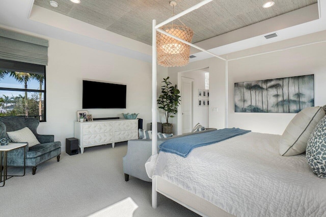 carpeted bedroom featuring a tray ceiling and a chandelier