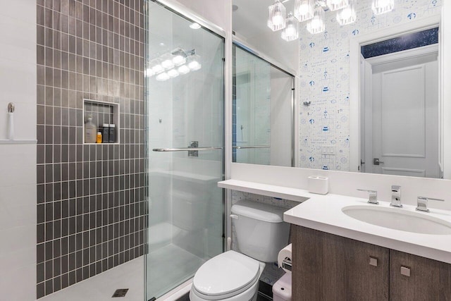 bathroom featuring vanity, toilet, and a shower with shower door