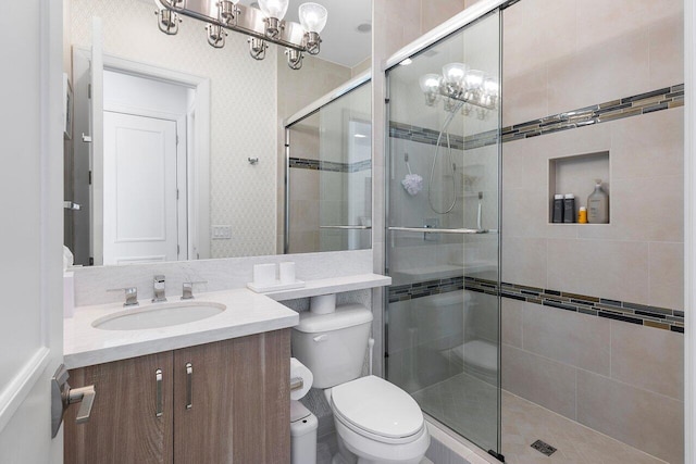 bathroom with vanity, an enclosed shower, an inviting chandelier, and toilet