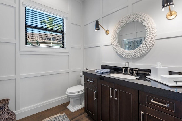 bathroom with vanity, toilet, and hardwood / wood-style floors