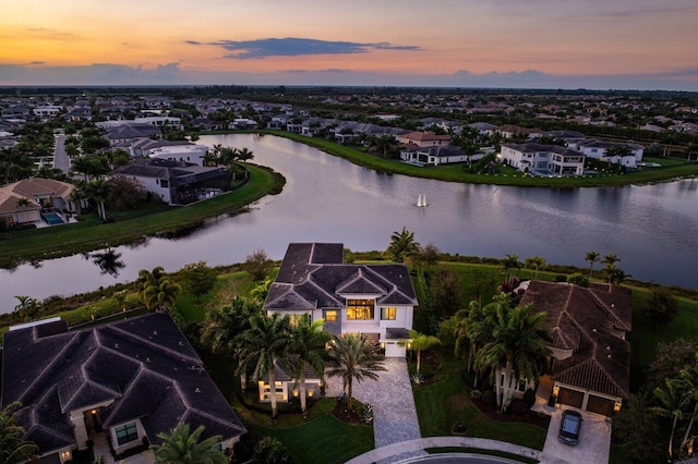 aerial view at dusk featuring a water view