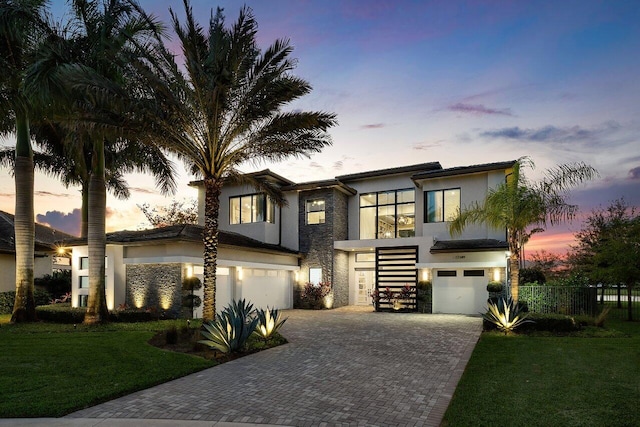 contemporary house featuring a garage and a lawn