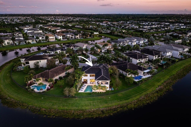 aerial view at dusk featuring a water view