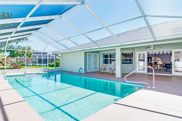 pool featuring glass enclosure, french doors, a ceiling fan, and a patio area