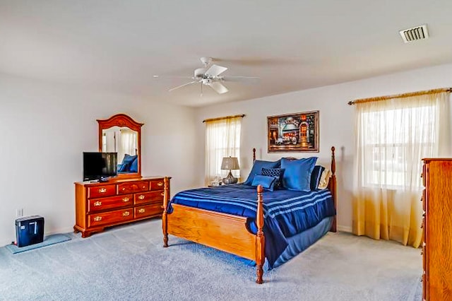 carpeted bedroom with multiple windows and ceiling fan