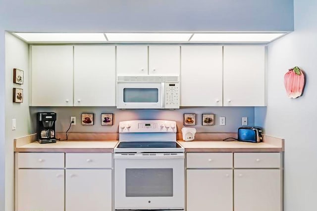 kitchen featuring white appliances and white cabinets