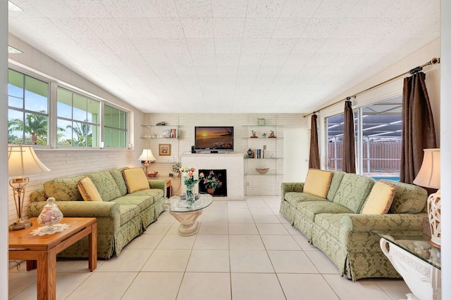 living room featuring brick wall, light tile patterned floors, and a fireplace