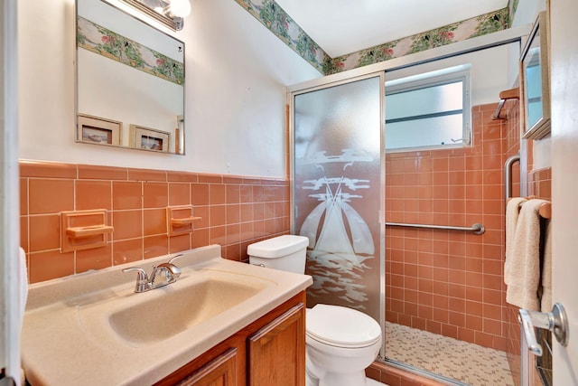 bathroom featuring tile walls, vanity, a shower with shower door, and toilet