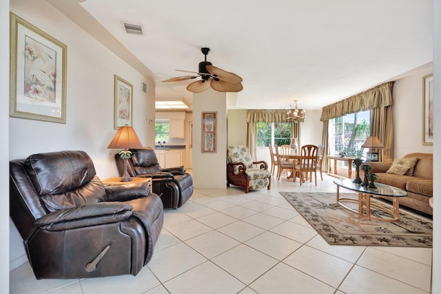 living room featuring ceiling fan with notable chandelier and light tile patterned floors