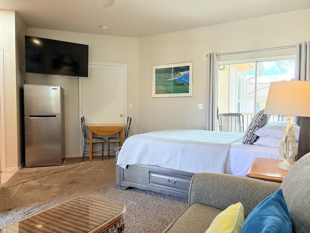bedroom with access to exterior, carpet, and freestanding refrigerator