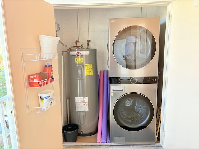 washroom featuring water heater, laundry area, and stacked washer / drying machine