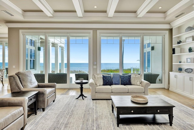 living room with visible vents, plenty of natural light, beamed ceiling, and light wood finished floors