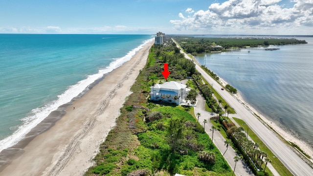 drone / aerial view with a water view and a view of the beach