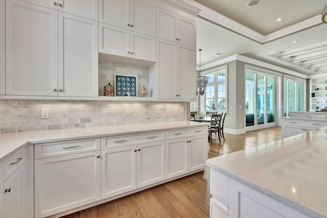 kitchen with ornamental molding, white cabinets, and light countertops