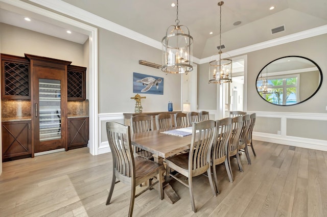 dining space featuring ornamental molding, a wainscoted wall, visible vents, and light wood-style floors