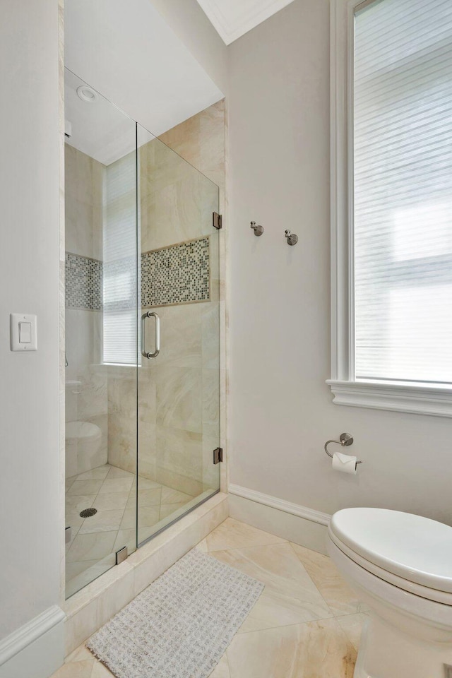 full bathroom featuring crown molding, a shower stall, toilet, and baseboards