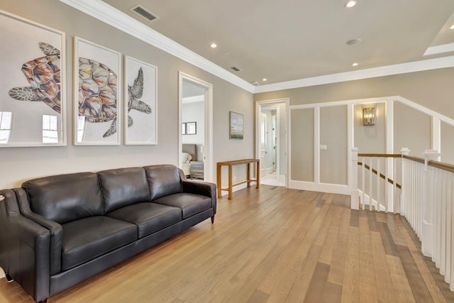 living area with ornamental molding, recessed lighting, visible vents, and light wood finished floors