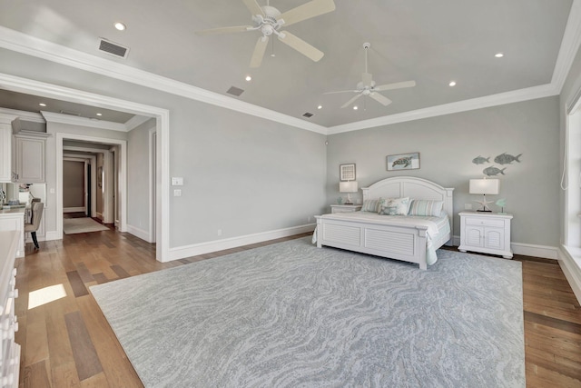 bedroom featuring baseboards, visible vents, wood finished floors, and ornamental molding