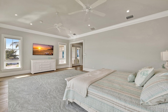 bedroom with baseboards, visible vents, wood finished floors, and ornamental molding